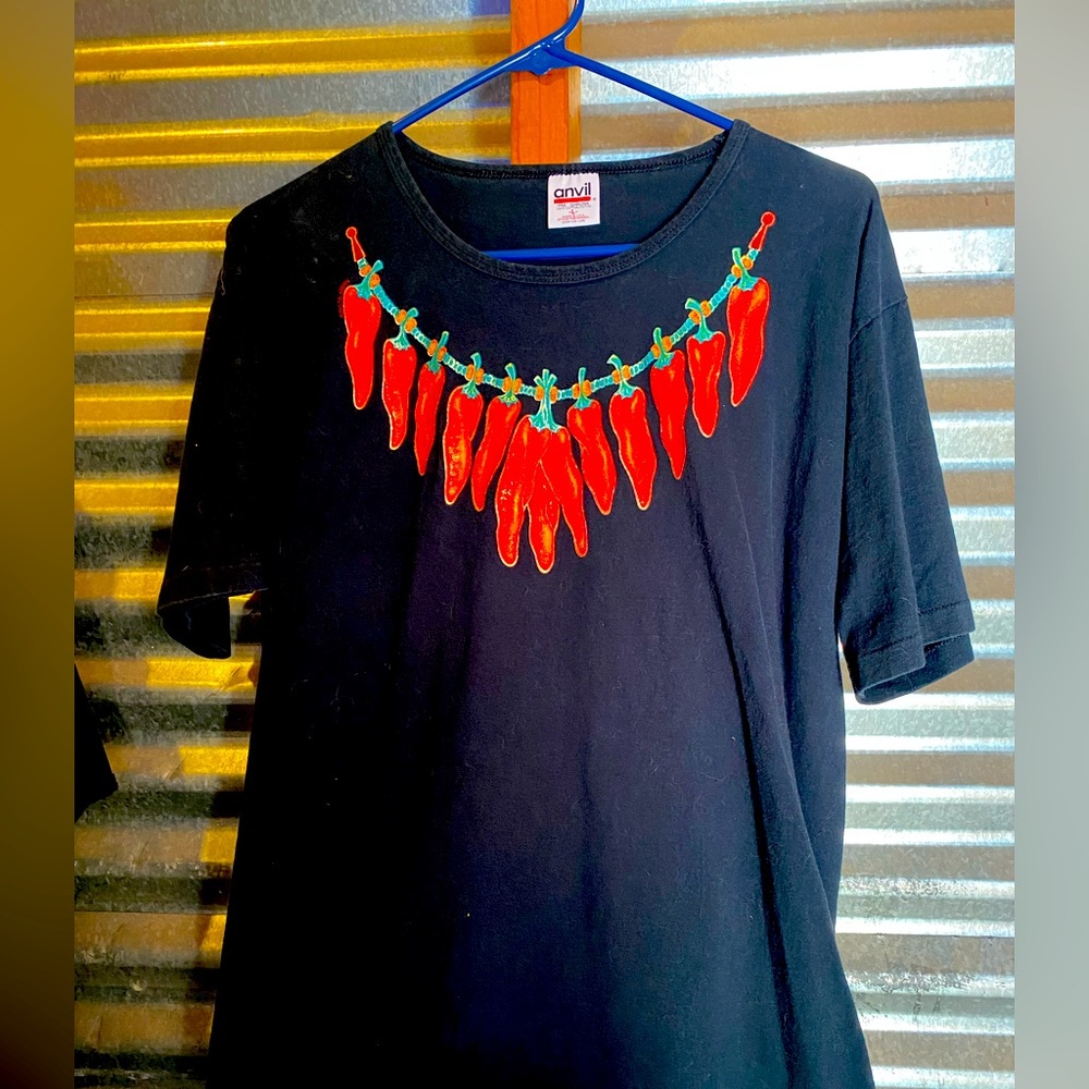 Black short sleeve women’s t-shirt with red chili peppers adorned as a necklace.